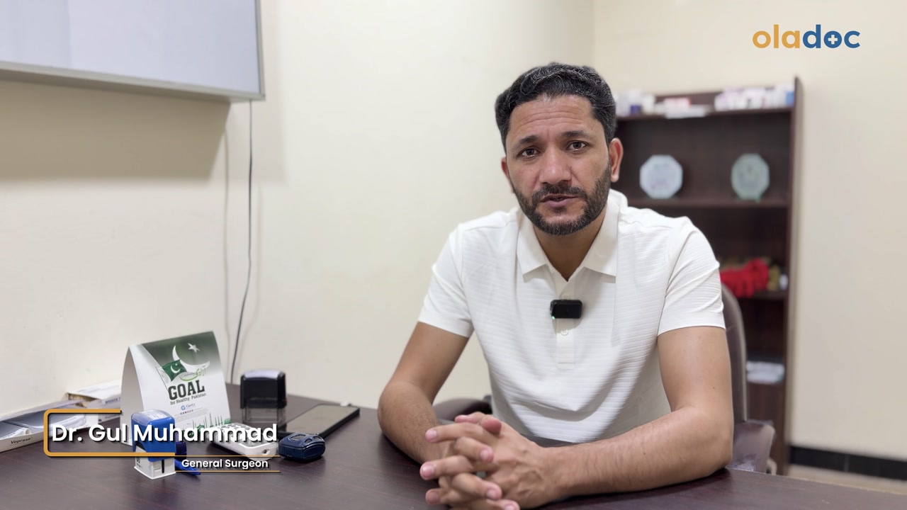 Dr. Gul Muhammad speaking directly to camera in his clinic